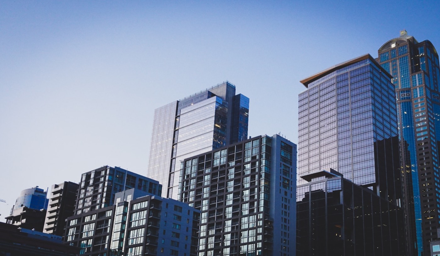 Residential apartment towers seen from street level against a blue sky